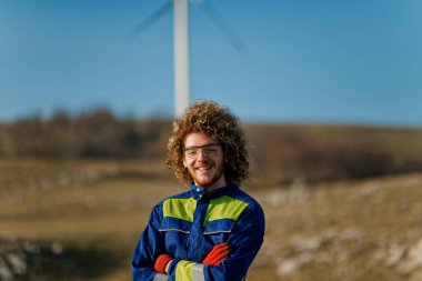 Mühendis mekandaki elektrik türbinlerinin bakımını ve işleyişini titizlikle denetleyerek optimum işlevsellik ve verimliliği sağlıyor..