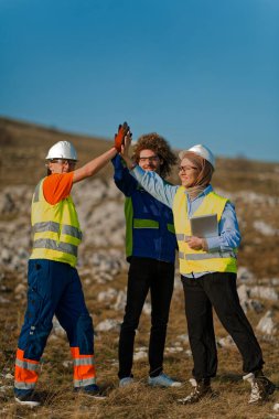 A dedicated team of engineers demonstrates effective teamwork while inspecting and assessing electric turbines in the field to ensure optimal performance and efficiency. clipart