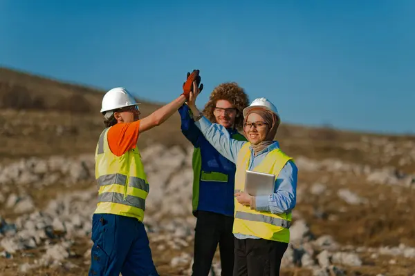 stock image A dedicated team of engineers demonstrates effective teamwork while inspecting and assessing electric turbines in the field to ensure optimal performance and efficiency.