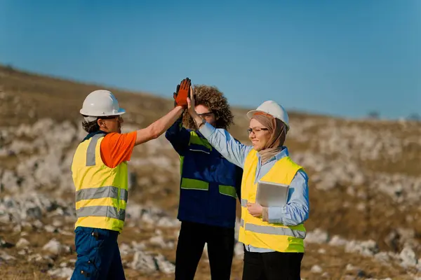 Mühendislerden oluşan bir ekip, sahadaki elektrik türbinlerini en iyi performans ve verimliliği sağlamak için inceleyip değerlendirirken etkili bir takım çalışması sergiliyor..