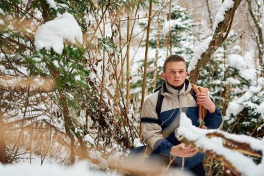 Kararlı bir dağcı, kışın kalbinde macera ruhunu somutlaştıran bir halat ve sırt çantasıyla donatılmış, karla kaplı huzurlu bir ormanda yelken açar.. 