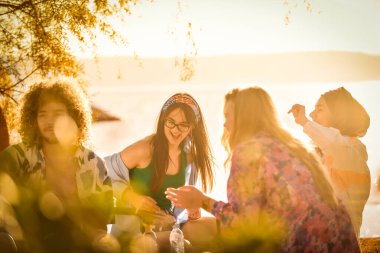 A group of friends gather on the beach sharing joyful moments filled with music, laughter and the warmth of togetherness, teenagers having fun on the beach clipart