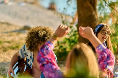 A group of friends gather on the beach sharing joyful moments filled with music, laughter and the warmth of togetherness, teenagers having fun on the beach clipart