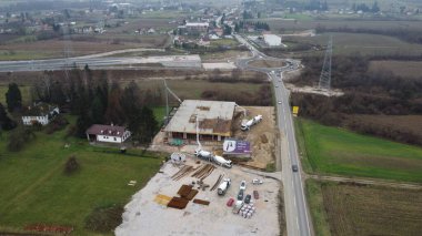 An aerial view captured by a drone showcasing the ongoing construction of a modern building, highlighting the work on the structure, scaffolding, and machinery on site clipart