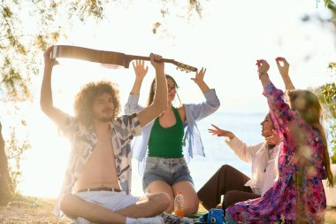 A group of friends gather on the beach sharing joyful moments filled with music, laughter and the warmth of togetherness, teenagers having fun on the beach clipart