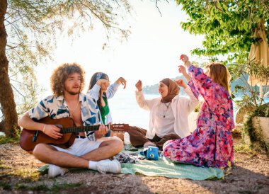 A group of friends gather on the beach sharing joyful moments filled with music, laughter and the warmth of togetherness, teenagers having fun on the beach clipart