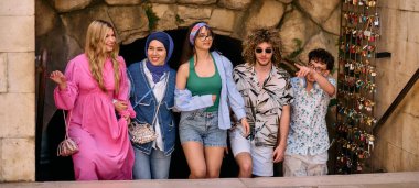 Yaz kıyafetleri içinde çeşitli turist grupları, geniş tebessümleriyle turistik şehirde geziniyor, gezintilerinin tadını çıkarıyorlar.. 