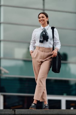 Şık bir Latin iş kadını şehrin hareketli sokaklarında elinde evrak çantası ve yüzünde kararlı bir gülümseme ile rahatça yürüyor.. 