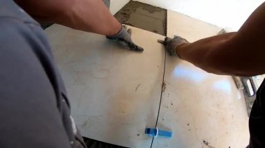 Seramik döşeme döşemesi takan profesyonel bir klasörün POV görüntüsü. Video, fayans yapıştırıcı sürme, fayansları yerleştirme ve onları zemine sabitlemek için bir çekiç kullanma sürecini kaydediyor. İdeal
