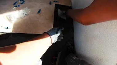 Seramik döşeme döşemesi takan profesyonel bir klasörün POV görüntüsü. Video, fayans yapıştırıcı sürme, fayansları yerleştirme ve onları zemine sabitlemek için bir çekiç kullanma sürecini kaydediyor. İdeal