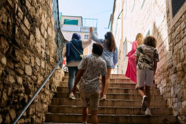 Bir grup mutlu turist Akdeniz şehrinin cazibesini ve kültürünü keşfediyor ve yaz tatillerinin tadını sonuna kadar çıkarıyorlar.
