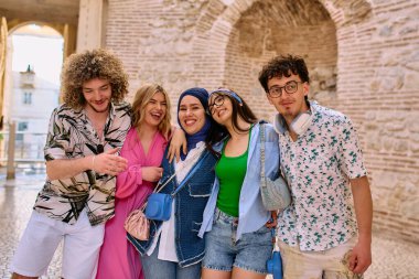 Yaz kıyafetleri içinde çeşitli turist grupları, geniş tebessümleriyle turistik şehirde geziniyor, gezintilerinin tadını çıkarıyorlar.. 