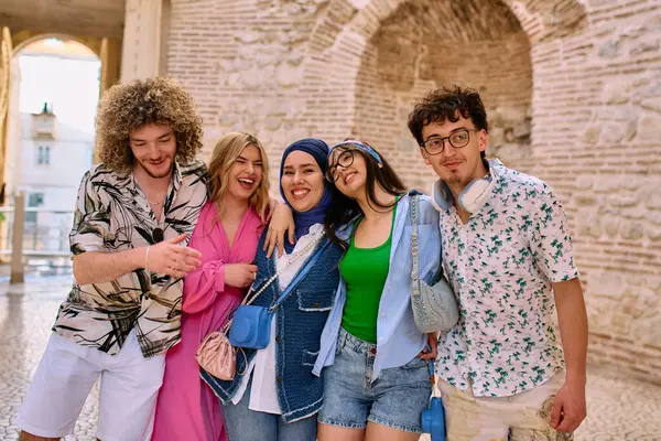 Yaz kıyafetleri içinde çeşitli turist grupları, geniş tebessümleriyle turistik şehirde geziniyor, gezintilerinin tadını çıkarıyorlar.. 