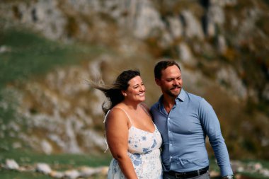 Sonbahar boyunca manzaralı bir dağ manzarasında kucaklaşan romantik çift, açık havanın ve aşkın tadını çıkarıyor..