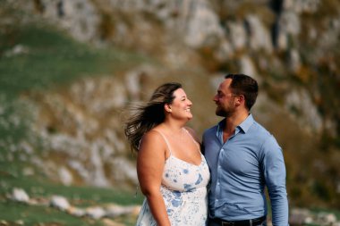 Sonbahar boyunca manzaralı bir dağ manzarasında kucaklaşan romantik çift, açık havanın ve aşkın tadını çıkarıyor..