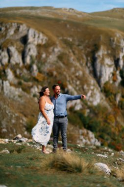 Sonbahar boyunca manzaralı bir dağ manzarasında kucaklaşan romantik çift, açık havanın ve aşkın tadını çıkarıyor..