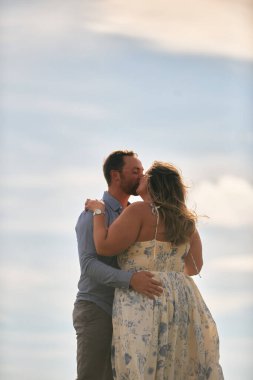 Çimenli bir dağ tarlasında neşeli bir şekilde dans eden erkek ve kadın aydınlık bir günde, doğada sevgi ve özgürlüğün tadını çıkarıyorlar..