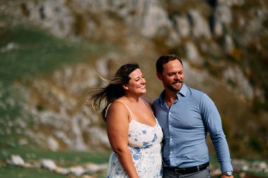 Sonbahar boyunca manzaralı bir dağ manzarasında kucaklaşan romantik çift, açık havanın ve aşkın tadını çıkarıyor..