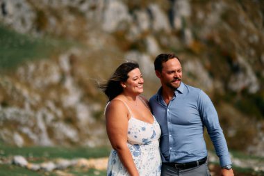 Sonbahar boyunca manzaralı bir dağ manzarasında kucaklaşan romantik çift, açık havanın ve aşkın tadını çıkarıyor..