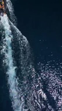 Sakin Adriyatik Denizi yüzeyinde hızla ilerleyen bir teknenin insansız hava aracı videosu. Su izi bırakıyor..