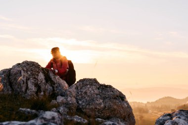 Güneşin doğuşunda Rocky Dağı 'na tırmanan kişi. Doğada azim ve mücadelenin sembolü olan altın gündoğumu sırasında kayalık dağa tırmanan kişi.