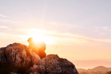 Güneşin doğuşunda Rocky Dağı 'na tırmanan kişi. Doğada azim ve mücadelenin sembolü olan altın gündoğumu sırasında kayalık dağa tırmanan kişi.