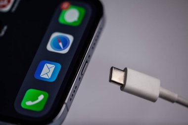 Gri arka planda beyaz C tipi şarj aleti olan yeni iPhone. Moldova,Hincesti 04.09.2023. Yüksek kalite fotoğraf