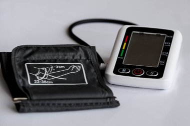 Tansiyon ölçme cihazı, beyaz tıbbi arka planda tonometre. Dijital elektronik tonometre. Baş ağrısı, hipertansiyon tedavisi ve tansiyon. Terapist ofisi. Yüksek kalite fotoğraf