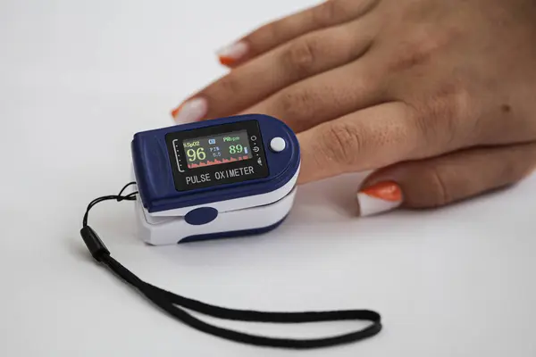 Nabzı ölçmek için modern tıbbi teknoloji. Bir kadının parmağında nabız oksimetresi deniyor. Hastane aletleri ve ekipmanları. Yüksek kalite fotoğraf
