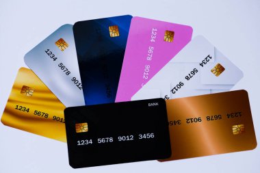 Gri arkaplanda altın, gümüş ve bronzun anlamını taşıyan farklı renkte banka kartlarının olduğu bir resim. Yüksek kalite fotoğraf