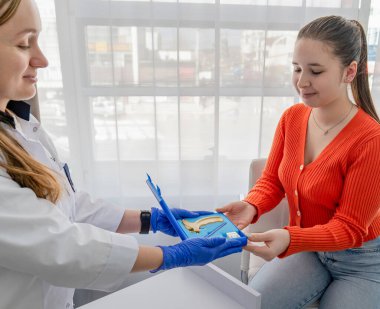 Kozmetik uzmanı müşterisine kulak delme aletlerini gösteriyor. Yüksek kalite fotoğraf