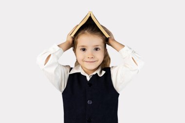 Yüzünde tebessüm olan genç bir kız okul üniformasıyla elinde bir kitap tutuyor. Saçları düzgünce arkaya bağlanmış ve kaşları coşkuyla kabarmıştı.