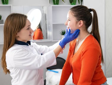 Beyaz eldivenli kozmetik uzmanı güzellik salonunda güzellik işleminden önce genç bayan müşterinin derisini inceliyor. Yüksek kalite fotoğraf