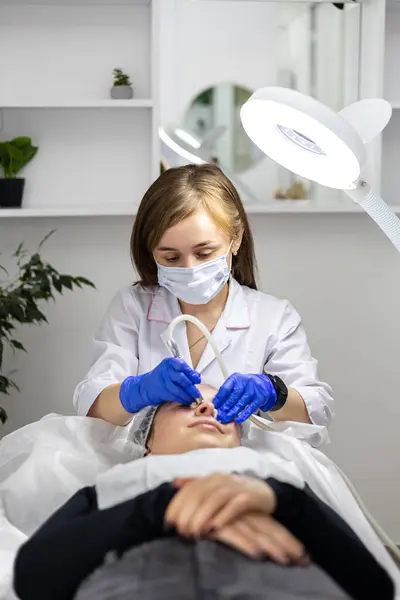 İğne mezoterapisi. Kozmetik uzmanı bir kadının yüzünde iğne mezoterapisi yapıyor. Güzel genç bir kadın mikro iğnelerle gençleştirme tedavisi görüyor. İğne kaldırma. Yüksek kalite fotoğraf