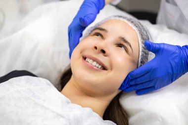 Kozmetik uzmanının yakın plan portresi güzellik salonundaki kadın müşteriler için canlandırıcı yüz işlemleri yapıyor. Güzellik tedavisi. Estetik kozmetoloji, yüz bakımı. Yüz bakımı. Yüksek kalite fotoğraf