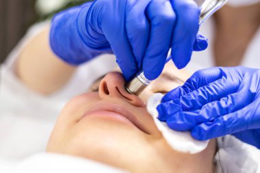 Donanım kozmetolojisi, mesoterapi, dermapen, çene bölgesinin tedavisi, yüz yenileme, yakın çekim, tıbbi eldivenler. Yüksek kalite fotoğraf