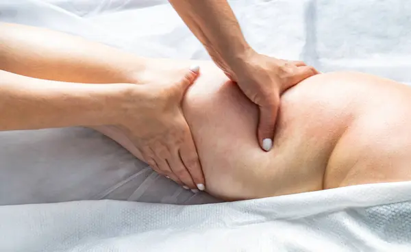 Usta masör kız için anti-selülit masajı yapıyor. Güzellik stüdyosundaki kadın kalçasına elle antiselülit masajı prosedürü. Yüksek kalite fotoğraf