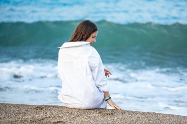 Asyalı manken kırmızı mayo ve hasır şapka giyer sıcak bir günde plaja oturur, güneş ve ultraviyole ışınlar güzel kadınların koruyucu tabakasına çarpar. Spa, güneş kremi, kozmetik, sağlık konsepti. Yüksek