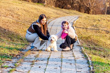 Çok güzel bir güneşle bir bahar günü, iki kız çok güzel beyaz bir köpekle yürürken şaşırdılar. Kızlar böyle bir hayvan arkadaşa sahip oldukları için çok mutluydular. Yüksek kalite