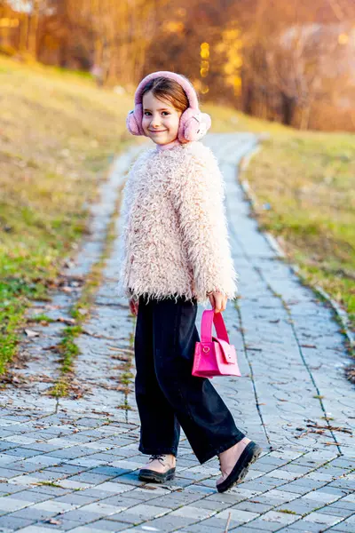 Küçük bir kız çok tatlı ve çekicidir, sağlıklı bir zihne ve vücuda sahip olmak için parkta yürür. Kız bir model ve çok çekici giyinmiş, uzman bir stilistle donatılmış. Yüksek