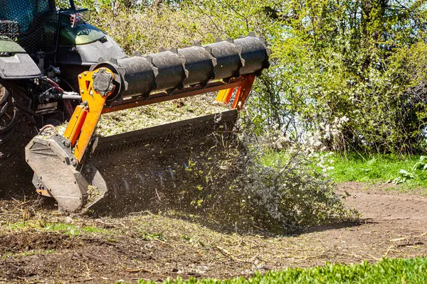 Orman temizliği konusunda uzmanlaşmış bir traktörün resmi tüm ağaçları ve çalıları yok etme sürecinde. Ormanların tahrip edilmesini durdurun. Doğayı yok eden büyük bir traktörün resmi. Yüksek kalite