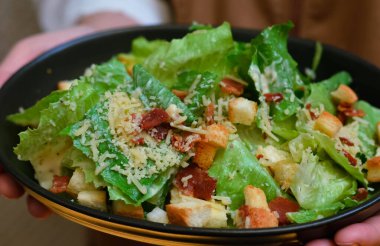 Caesar salad served with organic lettuce, crispy bread and sprinkled with cheese is a meal for health lovers.