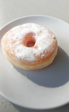 Tabaktaki beyaz pudra şekerli çöreklerin fotoğrafı.