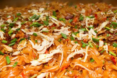 Kızarmış Kwetiau 'nun tatlı ve lezzetli bir tadı var. Kwetiau 'nun yanı sıra balık köftesi, yumurta, hardal yeşili ve lahana gibi çeşitli malzemeler de içerir. Yakın plan fotoğraf..