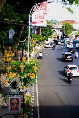 Kentsel bir yolda motosiklet sürücüleri, yol kenarındaki dükkanlar, asfalt, sürücüler