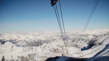İsviçre Alpleri 'nde Buzul 3000 teleferiği. Kayak asansörleri aşağı sarkıyor tellerde.