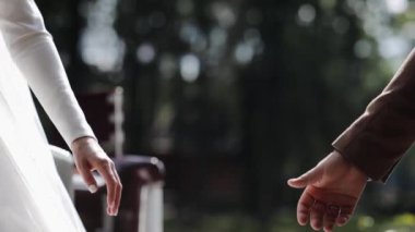 Düğün çifti günbatımında el ele tutuşup yavaş çekimde aşk, evlilik, gelin, güzel, kutlama, romantik koca, mutlu kadın, merasim, kadın, beyaz