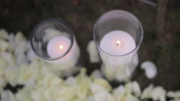 婚礼期间 美丽的蜡烛在玻璃瓶或草地上的花瓶中燃烧 靠近点 — 图库视频影像