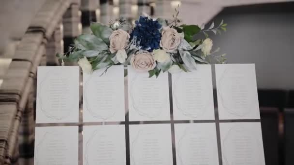 特別なイベントやパーティー中にレストランで花で飾られた結婚式のレセプションシートチャート ゲスト席のリスト — ストック動画
