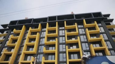 Sovyetler Birliği sonrası ülkede konut inşaatının yeni modern cephesi. Dış tarafı sarı balkonlu bir bina. Sabit çekim